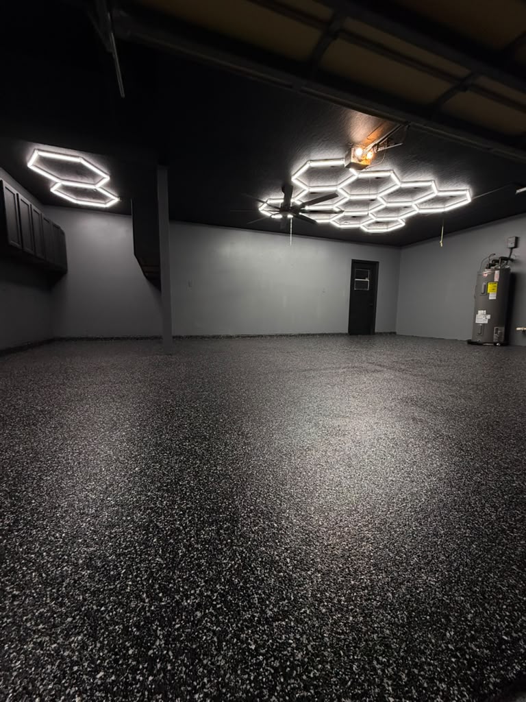 Garage with dark flake flooring and hexagon ceiling lights