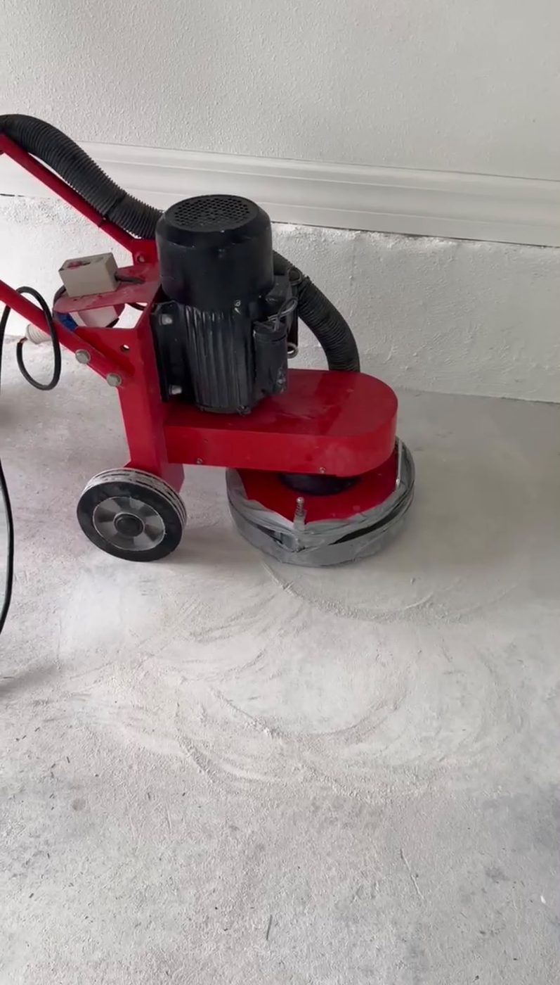 Floor grinder preparing a concrete garage slab before coating