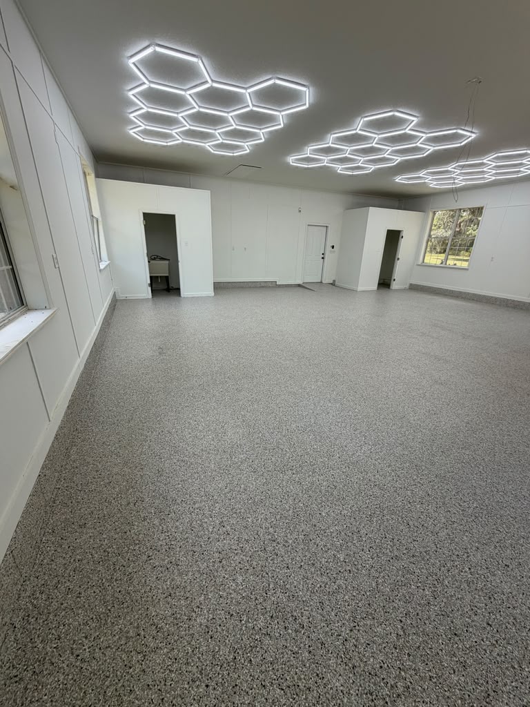 Garage with light flake flooring and hexagon ceiling lights